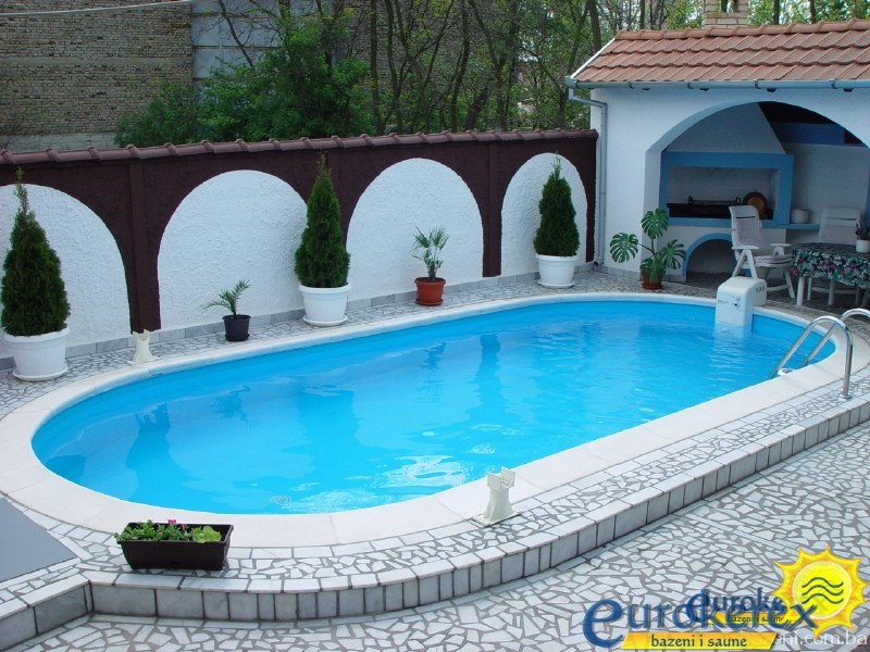  Ova slika prikazuje elegantan vanjski prostor s bazenom kao središnjim elementom, što ga čini atraktivnom destinacijom za rekreaciju i zabavu u vašem dvorištu.